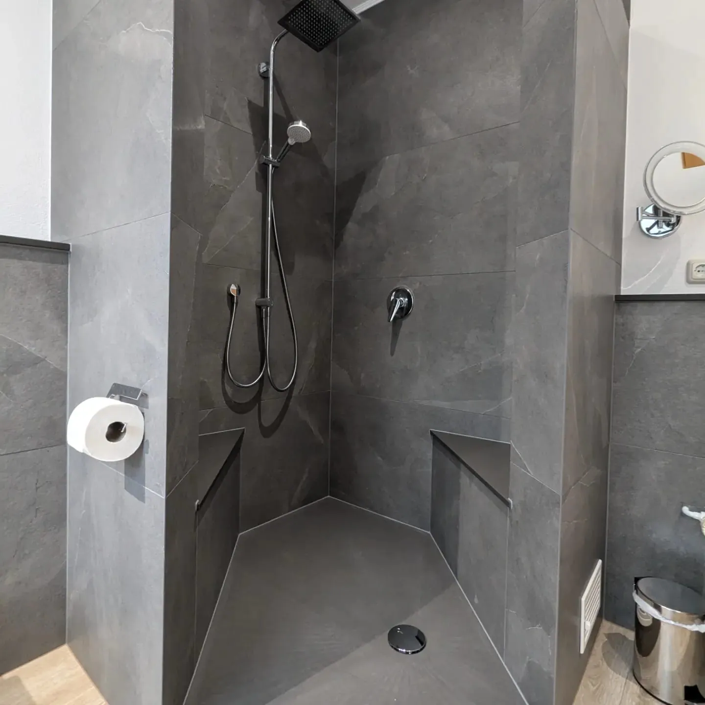Bad mit dunklen Fliesen und freistehender Wanne